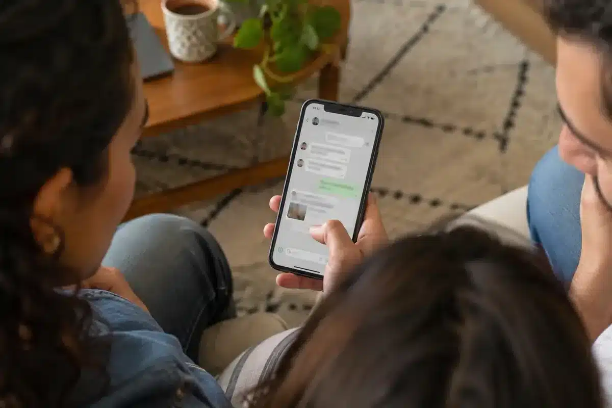Pessoas consultando conversa de grupo em smartphone durante encontro cotidiano, em cena editorial ilustrativa